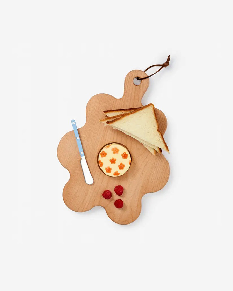 wood squiggle serving board with food laid out on it