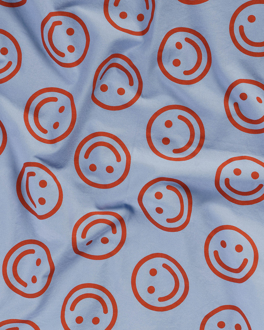 up close of pillowcase with cornflower background and red smiley faces