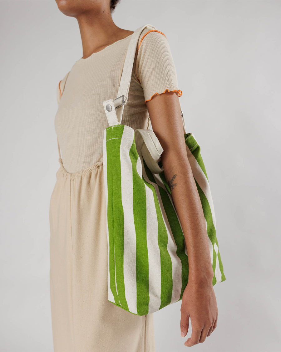 model wearing white and green vertical stripe duck bag