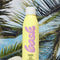 editorial image of bask spf 50 non-aerosol sunscreen spray in sand and palm tree background