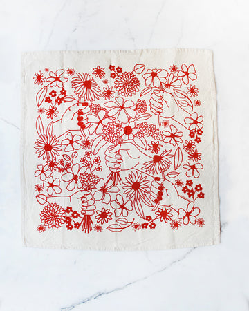 cream tea towel with red floral and hand graphic