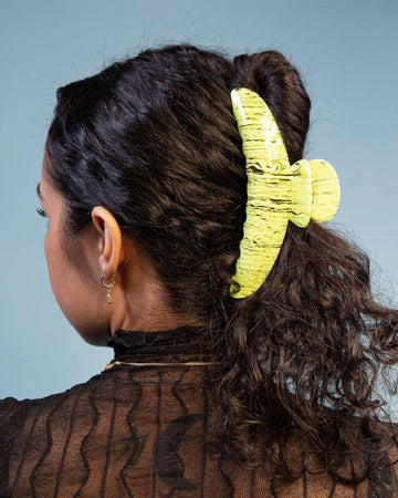 model wearing large lime green squiggle hair claw