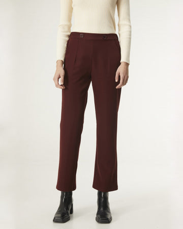 model wearing burgundy cropped trousers with cream sweater and black boots