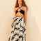model wearing black and white floral abstract midi skirt with waist tie and black top