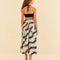 backview of model wearing black and white floral abstract midi skirt with waist tie