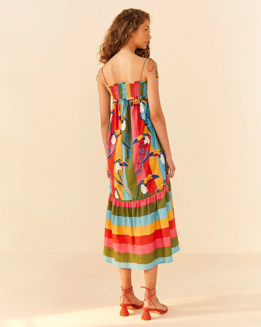 backview of model wearing multicolor stripe midi dress with smocked bodice and fun toucan print