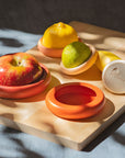 set of five terracotta toned food huggers on various fruits