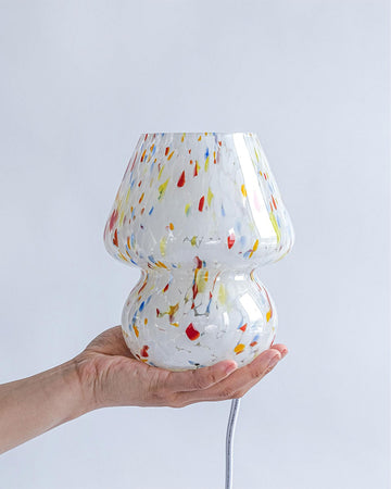 model holding white mini mushroom lamp with multicolor streaks