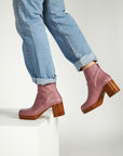 model wearing pair of mauve booties with wood stack heel and platform