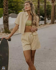 model wearing tan gingham cropped button down top with matching shorts