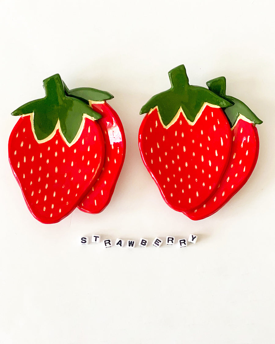 stack of strawberry shaped dishes with the word 'strawberry' written in letter beads