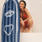 model next to blue inflatable surf board with an eye, a heart and a sun graphic.