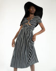 model wearing black and white stripe midi dress with cut out front and black floppy hat
