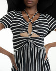 up close of model wearing black and white stripe midi dress with cut out front and black floppy hat
