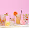 pint glasses filled with various beverages, fruit, and drink umbrellas
