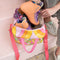 model holding open pink, yellow, orange groovy print roller skate bag and putting skates in