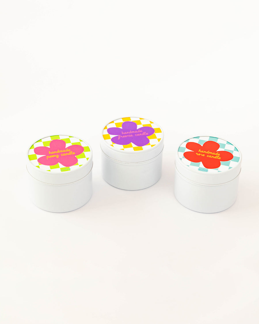 set of three candles in tin packaging and checker and floral print lids