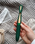 model holding green bamboo toothbrush with matching cover