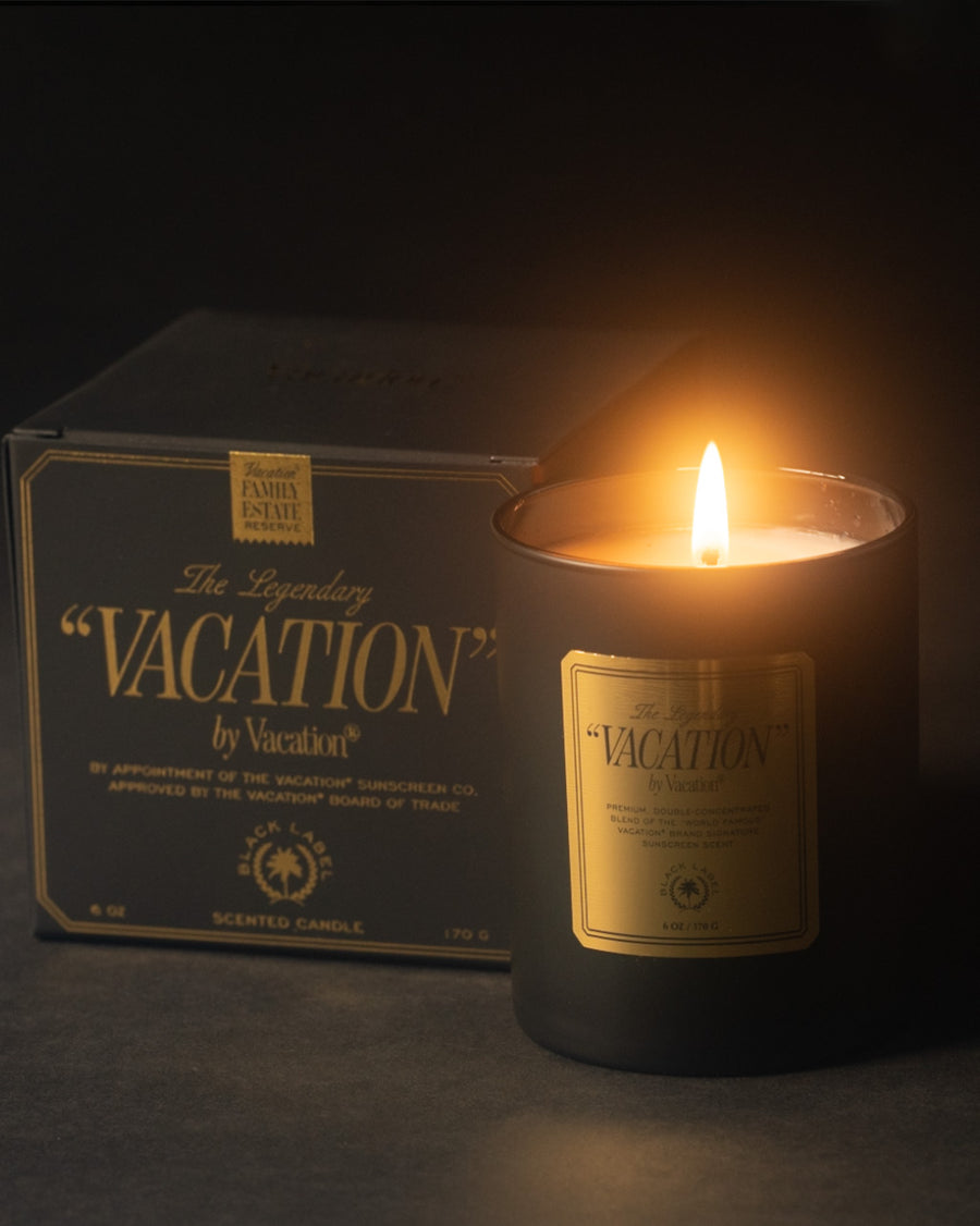 vacation sunscreen candle with black matte jar and gold label with matching box