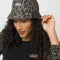 model wearing green vans bucket hat with white embroidered vans logo and brown leopard print