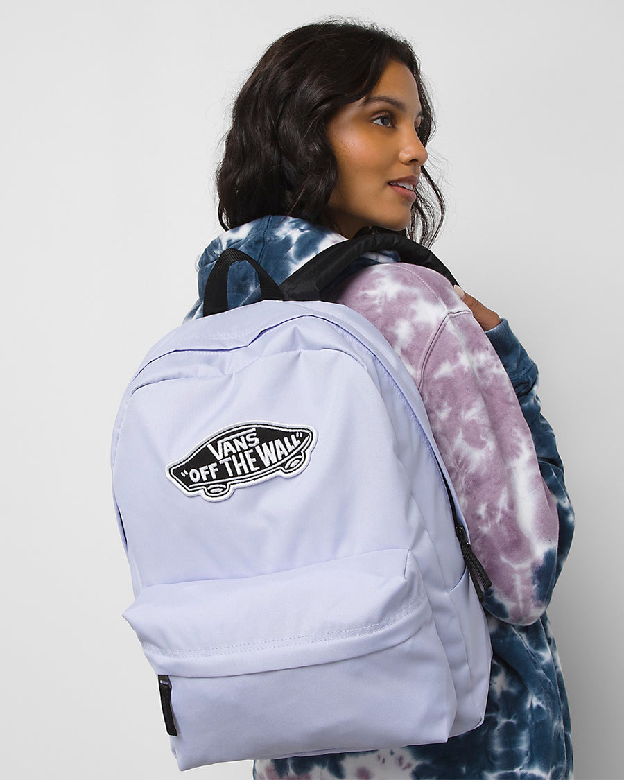 model wearing lavender backpack with 'vans off the wall' patch on the front