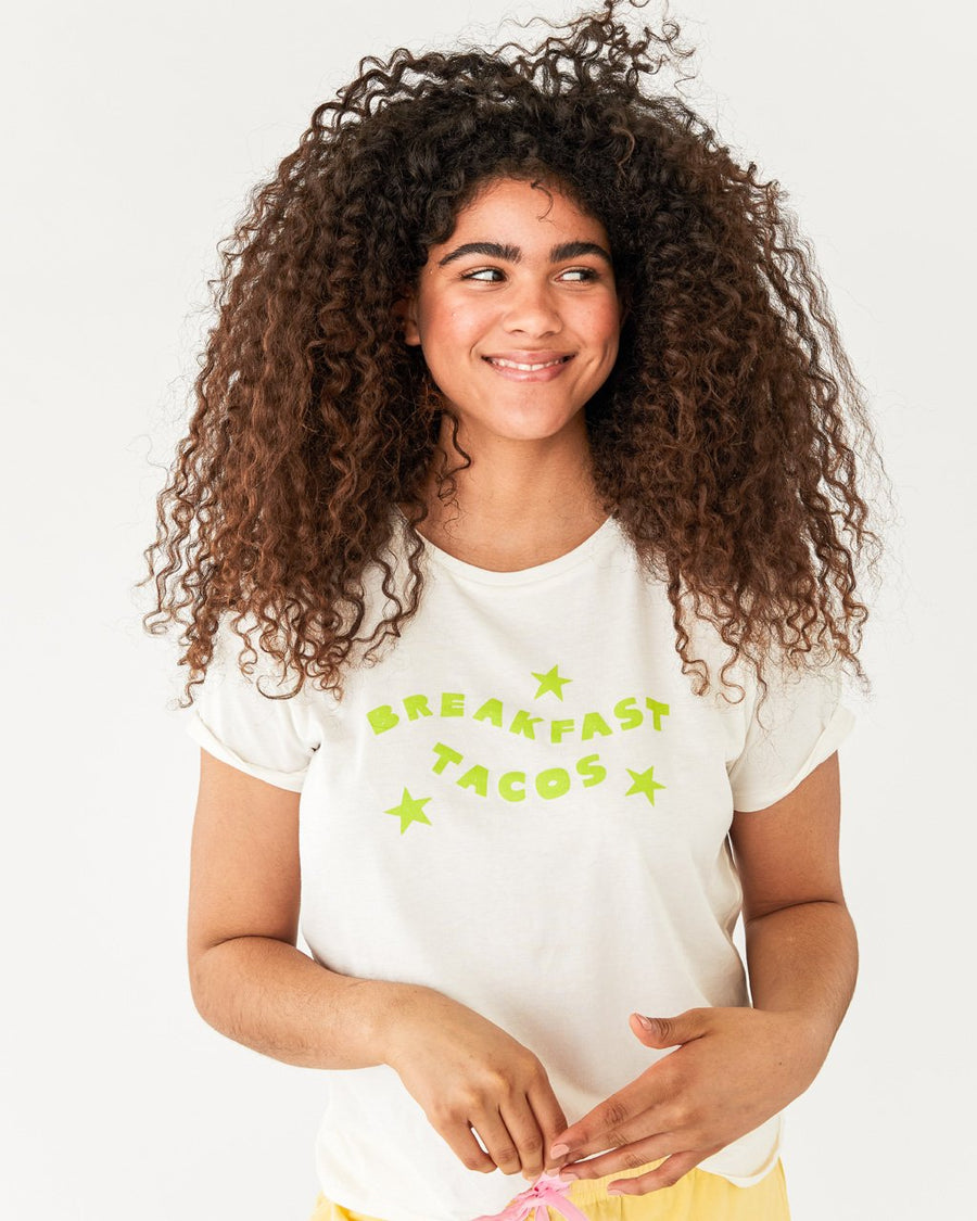 model wearing solid white tee with the words breakfast tacos in lime green