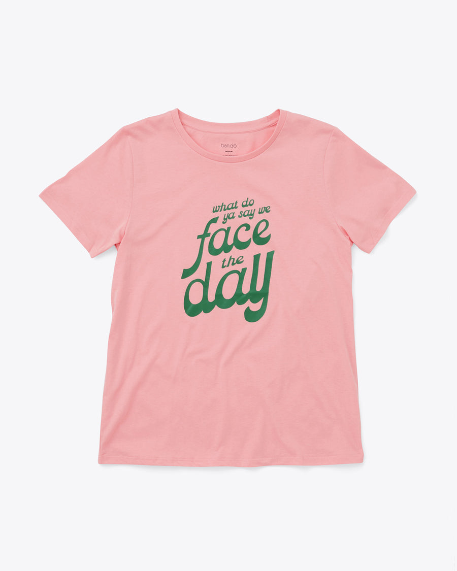 pink t-shirt with green text graphic reading "what do ya say we face the day"