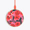 circular wireless charging pad in bold pink floral print with red charging cord