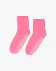 pink cozy socks with tonal "DOING NOTHING" text on sole