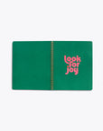 interior centerfold of spiral bound notebook with solid green pages and "look for joy" text graphic in pink on righthand page