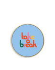 charging pad with blue ground and multicolor 'take a break' text on the front. 