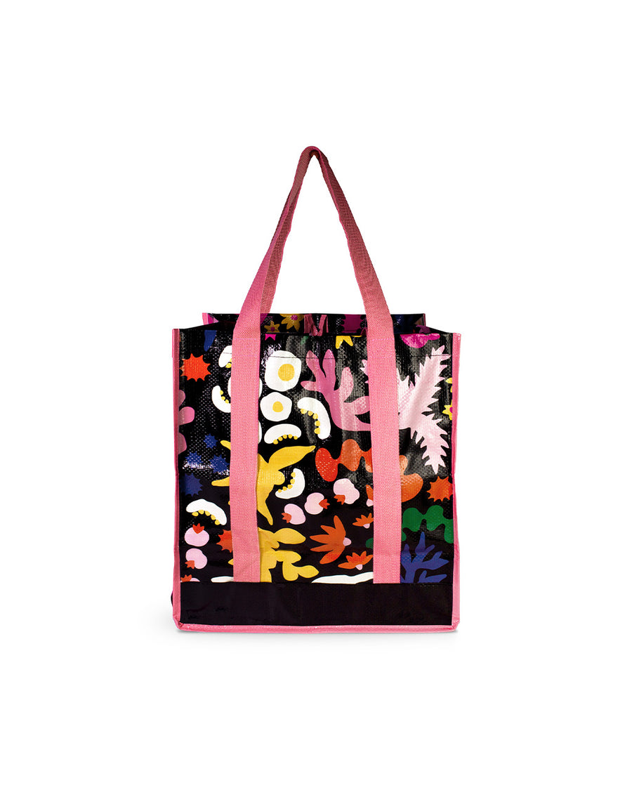 front view of reusable market bag with black ground, pink trim/straps, and all over multicolor abstract floral print