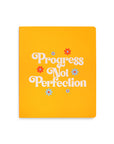 yellow undated planner with 'progress not perfection' across the front