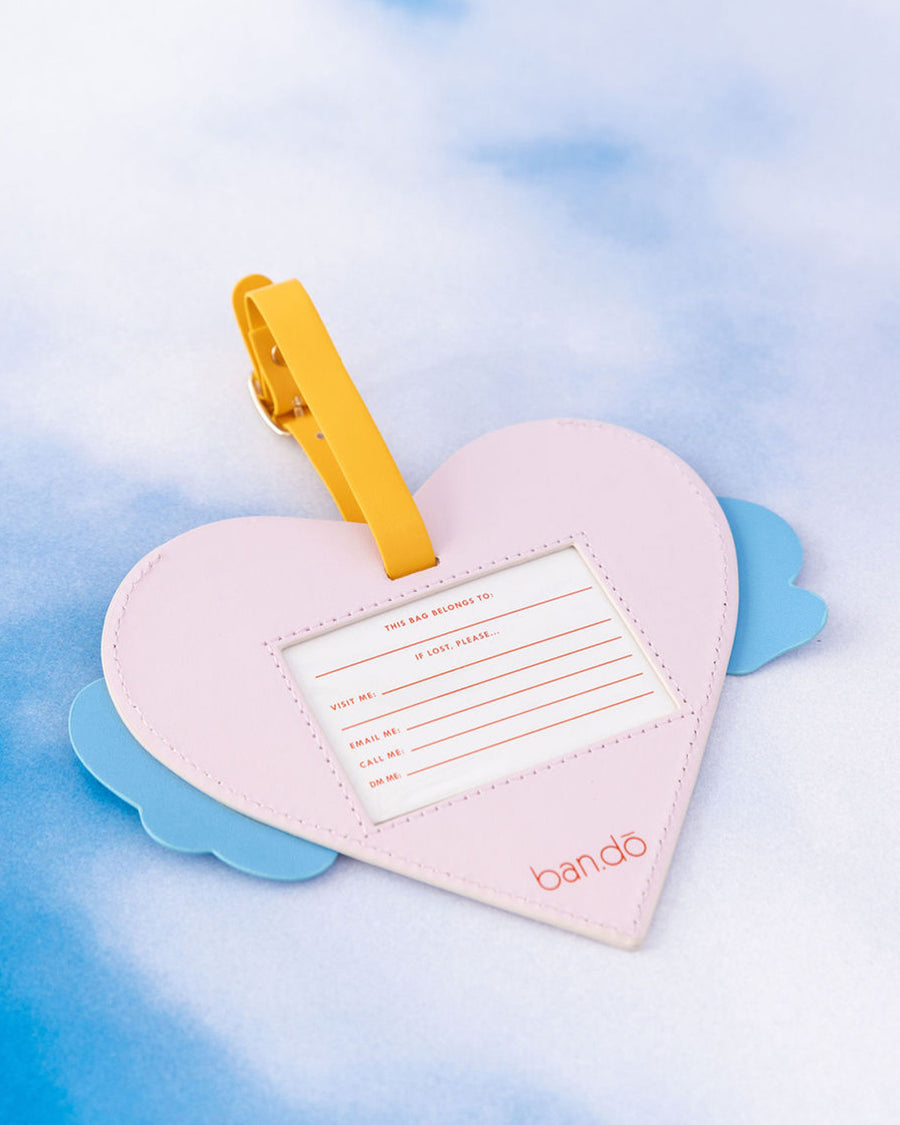 back view of red heart shaped luggage tag with blue and white 'Howdy!' in bubble letters