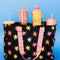go go work bag with black ground, colorful starburst print and two sides pink/yellow straps filled with cups