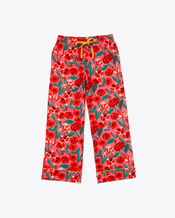 long pajama pants in red and pink bold floral pattern and yellow tie waist and piping detail at the ankle