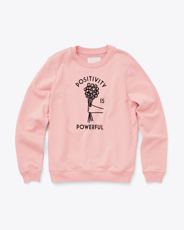 light pink sweatshirt with the words positivity is powerful and a daisy bouquet in the middle
