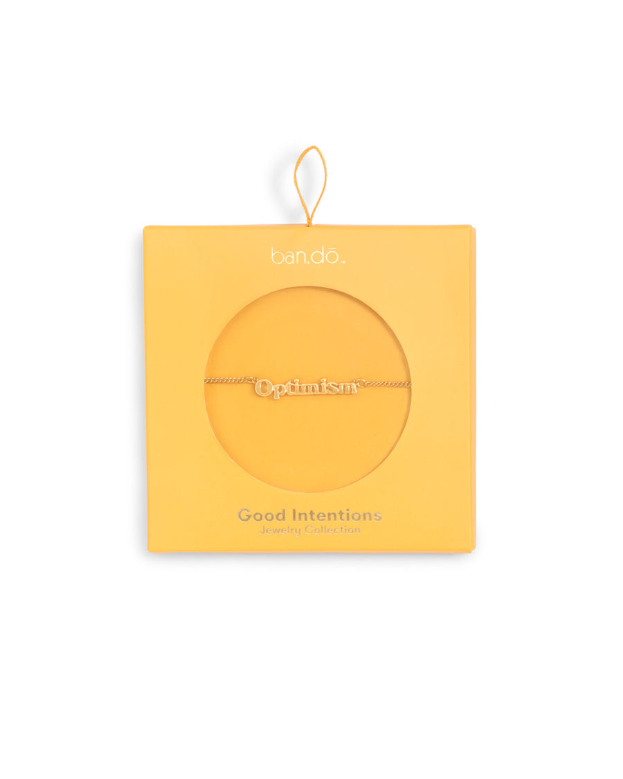 gold chain necklace with the word optimism shown in yellow box packaging