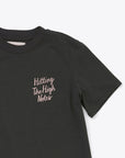 detailed image of black t-shirt with word graphic "Hitting The High Notes" in blush pink text.