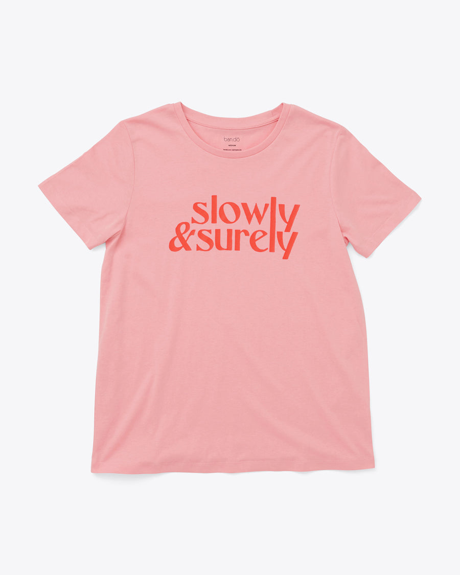 pink t-shirt with red "slowly & surely" text graphic