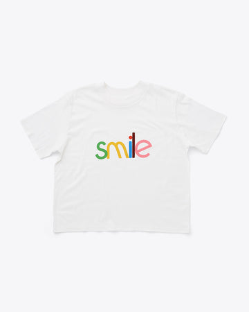 ivory cropped crew neck tee with multi color 'smile' across the front
