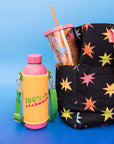 editorial image of pink stainless steel water bottle with yellow and green water bottle sling with the words '100% stardust' across the front