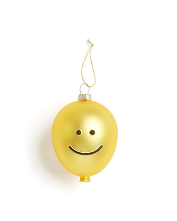 Yellow glass ornament with a smiley face. 