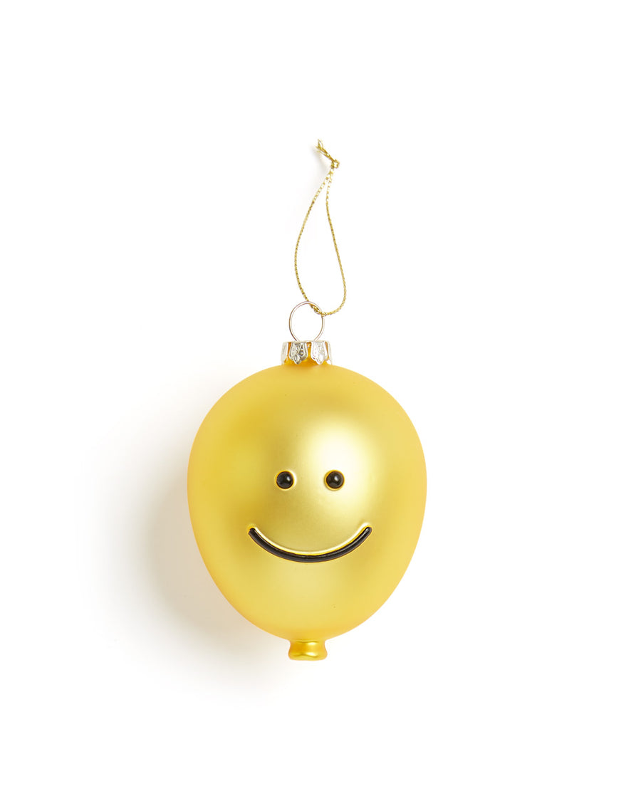 Yellow glass ornament with a smiley face. 