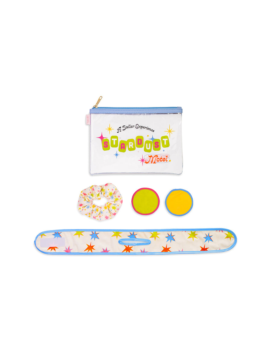 home spa kit with starburst headband, two reusable makeup remover pads, scrunchie and a clear pouch that says 'a stellar experience: stardust motel' across the front