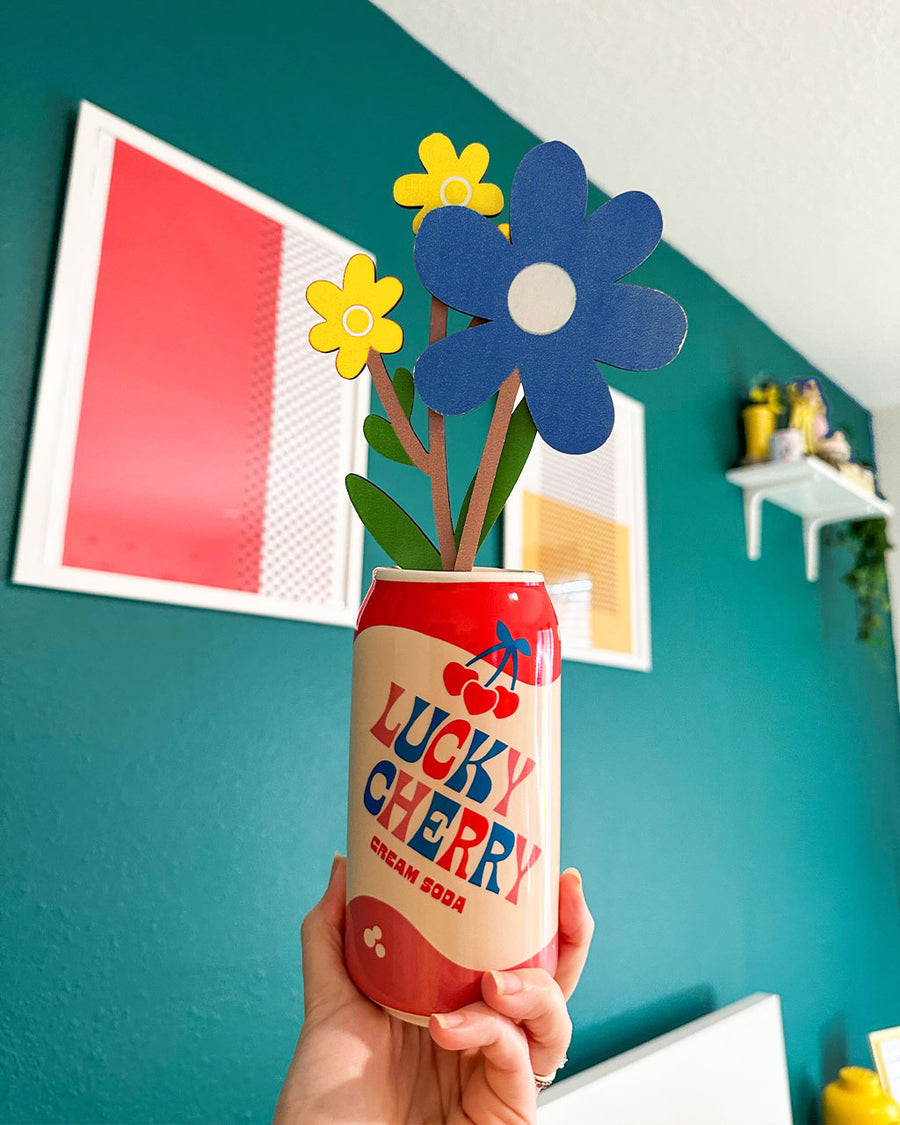 model holding lucky cherry cream soda with cardboard flowers inside