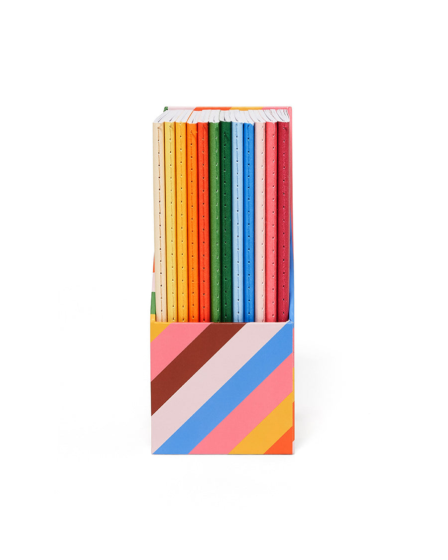 front view of 12 wellness notebooks in rainbow holder