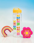 editorial image of yellow and multicolor water bottle that says 'drink more water' and rainbow and flower de-stress ball