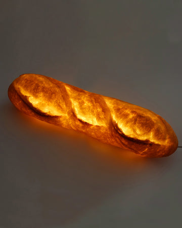 lamp made from a loaf of bread, glowing from a bulb
