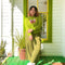 Woman in a green outfit standing on a green front porch